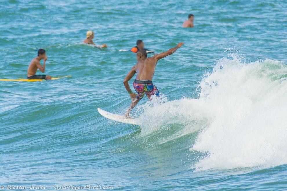 Imagem de vários surfistas no mar da Praia da Tiririca.